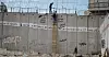 To menn klatrer over den israelske separasjonsmuren fra den palestinske byen al-Ram. Derfra tar de seg inn i Jerusalem.