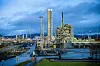 TESTANLEGGENE: Her foregår uttesting av CO₂-fangst. Til venstre for veien, ligger raffineriet på Mongstad som er Norges største utslippspunkt for CO₂. Til høyre for veien   er testanlegget. Nærmest er anlegget for CO₂ fangst ved hjelp av ammoniakk. Det høye tårnet er der uttesting av amin for å fange CO₂. Skjult bak aminanlegget kommer det tredje testområdet som er under utbygging. Der skal det legges til rette for mobile renseanlegg.