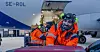 VARIERT ARBEID: En av mange oppgaver for de ansatte i Avinor på Svalbard lufthavn, er å tømme flyene for bagasje. Jo Gjerstad og Gudmund Klovning (i bakgrunnen) jobber i tillegg i brann- og redningstjenesten.