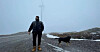 Terje Haugen, en av tre som driver reindrift i Nord-Fosen Siida. Her foran en vindturbin i vindkraftanlegget ved Roan i Åfjord kommune.