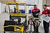 Mens Simen Totland Bergsholm (20) fra Møller Bil Stavanger, mekaniker for lette kjøretøy, feilsøker denne golfbilaktige snøfresetefargede farkosten. Også han var med på VM i Lyon i fjor.