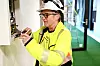 Laila Karin Hjelmeland titter bak fasaden på et panel. Ellers går det mye i ­lamper om dagen, og merking av kabler.