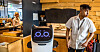 Serverings- og rydderoboten Bella er foreløpig en attraksjon blant reisende på Oslo lufthavn. Isak Hirsi synes det er artig å jobbe med en robot.