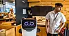 Serverings- og rydderoboten Bella er foreløpig en attraksjon blant reisende på Oslo lufthavn. Isak Hirsi synes det er artig å jobbe med en robot.
