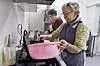 FRIVILLIGE: Anne-Britt Bjerk (nærmest) og Inger-Karin Jakobsen har kjøkkentjeneste. De sørger for at seniorene får vafler og kaffe når treffet begynner.