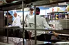 KOKKER IN SPE: Faglærer og kokk Mikael Eskman (til venstre) sammen med elever i restaurant- og matfag som har det travelt på kjøkkenet til skolens egen restaurant.