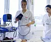 Kristiansen folder blodtrykksmåleren rundt den smale armen og bruker det mobile apparatet for å lese av verdiene.