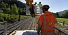 Nils Olav Nilssen (t.v.) og Gaute Skurdal sjekker om kjøreledningen går der den skal og om det er jording i stolpene. I forgrunnen står Aslak Halstensgård.
