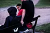Moutasem Nahar snakker med jenta på benken. Ved siden av henne sitter kompisen.