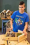SISTE FINPUSS: Mateo Dale gjør siste finpussen på insekthotellet sitt.