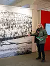 Utstillingsansvarlig Gunhild Lurås viser fram det første 1. mai-toget som ble arrangert på Rjukan i 1908. Bare én av de som er synlige på bildet, er en kvinne.