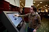 HJELPER: Bibliotekar Anders Kvernberg viser hvordan man kan finne fram på stor skjerm.