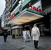 T-baneturen til sentrum er ikkje lang. Men når den eine arbeidsdagen ofte sluttar klokka fire, og den neste begynner halv fem, tel kvart minutt. I dag har ho litt betre tid og spaserer avslappa gjennom den tunge hovuddøra.