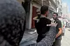 Et barn reddes ut etter flyangrep på flyktningleiren al-Bureij i Gaza torsdag.