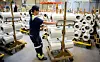 Hvert år produserer 3B Fibreglass på Birkeland 22 millioner kilometer med glassfibertråder. Ratchanok Kettrong håndterer stativene glassfiberrullene henger på.