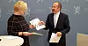 Finansminster Siv Jensen mottar OECDs landrapport om Norge fra OECD-direktør Alvaro Pereira.