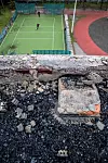 Noen videregåendeelever spiller fotball i en ballbinge rett ved en skole som er blitt bombet. Bildet er fra september i byen Kharkiv.
