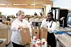 07:57 Tomme melkebokser må byttes ut med nye etter frokost. Mariann Evensrud og kokkelærling Maybel Boateng samarbeider om jobben.