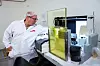 SJEKKER: Bak blyglasset tar de stikkprøver av glassene som allerede er inspisert av Robot Inspection Machine.