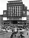Valgresultatet fra stortingsvalget i 1936 vises i søyler på fasaden av Folketeaterbygningen på    Youngstorget. Plakatene viser Oscar Torp og Johan Nygaardsvold.