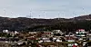 Noen av vindturbinene i Midtfjellet vindpark i Fitjar kommune. Deler av Fitjar sentrum i forgrunnen.