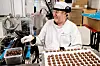 SJOKOLADE: Fotografen ble helt svimmel av glede og lukt da han oppdaget at Brynild også produserer sjokolade. Her er det Lasse Jensen som gjør klar bringebærsjokoladen, mens klassikeren Risbrød produseres på linja ved siden av.  – Jeg er nok mer fan av salt godteri, så jeg kan jo godt si at Stupedama er favoritten siden du er her, smiler Jensen. Brynild produserer også nøtter under merkevaren Den Lille Nøttefabrikken.