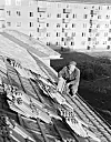 Taktekker Rolf Bjørnstad legger teglpanner på en OBOS-blokk i Teisen-området. Januar 1952.