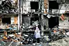 RAMMET: Ukrainas befolkning er hardt rammet av Russlands invasjon. Her ser en ukrainsk jente på et krater i en boligblokk etter en eksplosjon i hovedstaden Kyiv.