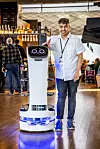 ATTRAKSJON: Serverings- og rydderoboten Bella er foreløpig en attraksjon blant reisende på Oslo lufthavn. Isak Hirsi synes det er artig å jobbe med en robot.