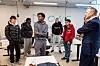 Her er mesteparten av droneklassen i prat med ministeren. Klasserommet er i et svært hangar-aktig rom på skolen.