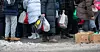 Frivillige ved Fattighuset i Oslo deler ut poser med mat til de som trenger det.