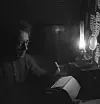 Her sitter Aksel Sandemose foran skrivemaskinen i lyset fra sin lampe hjemme på Kjørkelvik. Bildet er tatt i 1947.