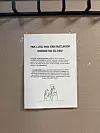 Plakat på veggen ved Skedsmokorset legesenter om nye sykmeldingstakster, med illustrasjon av lege og pasient.
