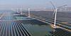 Vindturbiner ved et stort solkraftverk i Shandong-provinsen øst i Kina.