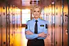 Lise Sannerud i lyseblå uniform står med armene i kors i en korridor.