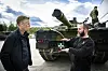 Christian Justnes og Dag Rune Linna står foran et militært beltekjøretøy på Rena leir.