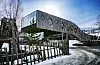 Snødekt Snow Resort Kirkenes med samiske symboler på fasaden og et tregjerde i forgrunnen.