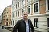 Asle Aase står utendørs i en bygate iført mørk jakke og blå skjorte.
