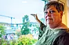 Ordfører Else Marie Stenhaug peker ut av vinduet på utsikten og en kran i Harstad.