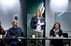 Kvinne presenterer Asbestportalen.no foran et panel med deltakere i et møterom.