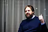 Torgeir Homme foran et grått sceneteppe, med høyre hånd hevet i tommel opp.