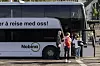 Passasjerer ved døren på en Nobina-buss ved et busstopp i byen.