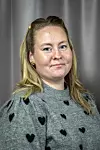 Portrett av Linn Rugland i en grå genser med svarte hjerter foran en grå bakgrunn.