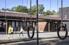 To bildekkhusker henger i skolegården, med elever og en skolebygning i bakgrunnen.