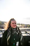 Linda Hægdahl står på en terrasse med bylandskap og åser i bakgrunnen.