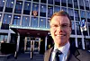 Erik Lahnstein smiler foran Utenriksdepartementets bygning i Oslo.