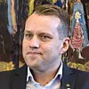 Portrett av Tor Egil Vangstad fra NOF foran et fargerikt kunstverk.