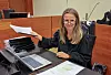 Advokat Ida Thue sitter ved en rettssalspult med dokumenter og bærbar datamaskin.