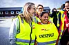 En gruppe streikevakter i gule og grønne refleksvester står samlet utendørs ved et industrianlegg.