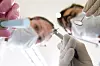 Tannlege og assistent i verneutstyr utfører tannbehandling med dentalinstrumenter.